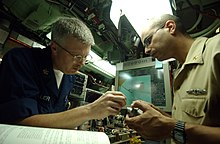 A Navigation Electronics Technician (ETV) Petty Officer First Class work on an assembly piece for the stern plane angle indicator aboard the submarine USS Annapolis US Navy 051025-N-9288T-112 Electronics Technician 1st Class Jay Miller, left, and Chief Electronics Technician Erick Encarnacion work on an assembly piece for the Stern Plane Angle Indicator.jpg