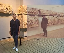 Victoria Price with a photo of her father, Vincent Price, superimposed in a nearby position at the British Museum in London. VLPMVPBritishMuseum.jpg