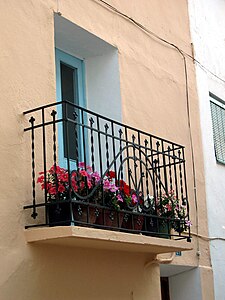 Detalle de balcón tradicional con flores en una casa de Torrebaja (Valencia), calle del Rosario.