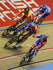 Mark Cavendish (foreground) handing over to Wiggins, on their way to winning gold in the Madison at the 2008 track world championships in Manchester. 2008 Track World Championships, Madison.jpg