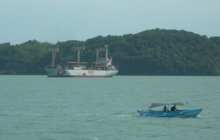 A cargo ship of 2GO Freight in the Iloilo Strait, with a pump boat and Guimaras Island in the background. 2GO Cargo Ship in Iloilo Strait with pumpboat.png