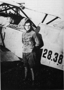 Photo noir et blanc d'un homme en uniforme devant un avion.