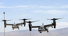 Two USAF CV-22s in a staggered pattern with their rotors vertical preparing to land at Holloman Air Force Base, New Mexico.