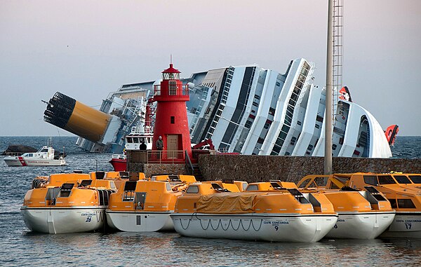 Aground with rigid lifeboats in foreground and inflatables hanging from the side of the ship