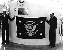 Photo en noir et blanc du drapeau présidentiel de Franklin Delano Roosevelt déployé sur le navire