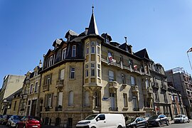 Maison d'angle avec la rue des Trois-Raisinets, quatre chats grignants sous la tourelle,