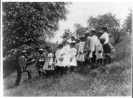 Field trip: school children outdoors listening to man, c. 1899, US