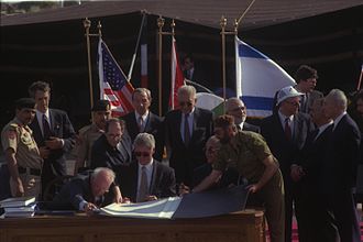 Secretary Warren Christopher (standing, center-left) looks on as the Israel-Jordan peace treaty is signed in 1994 Flickr - Government Press Office (GPO) - THE ISRAELI-JORDANIAN PEACE TREATY SIGNING CEREMONY.jpg