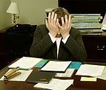 A double facepalm. Frustrated man at a desk (cropped).jpg