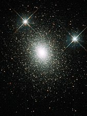 Milhares de estrelas se agruparam cada vez mais próximas em direção a um núcleo central, onde se misturam para formar uma área central branca sólida.
