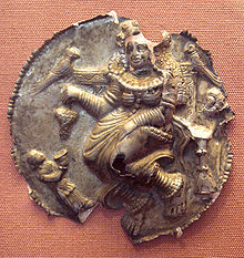 Devotee in Greek fashion, wearing a chiton, with the Buddhist goddess Hariti. Punjab, 2nd century BCE-2nd century CE. British Museum. HaritiWithChitonDevoteePunjab1-2Century.jpg