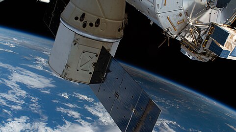 Dragon docked to the ISS; solar eclipse below