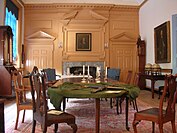 A room with large table and fireplace