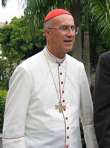 Cardinal Tarcisio Bertone wearing a tropical white cassock trimmed in cardinalatial scarlet in Santo Domingo, Dominican Republic