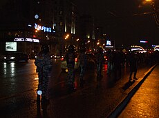 Police officers walking onto a road, observing protestors Imagem: Lvova Anastasiya.
