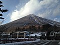 Photo couleur d'une montagne sur fond de ciel bleu nuageux.