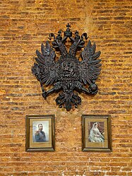 Герб Российской Империи и портреты Государя и Государыни в зале приходской школы собора