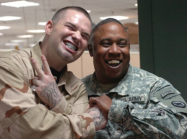 Paul Wall shows off his grills with a smiling soldier in Baghdad, 2007