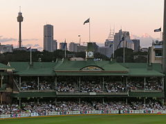 The historic Members' Pavilion under lights with the Sydney skyline behind