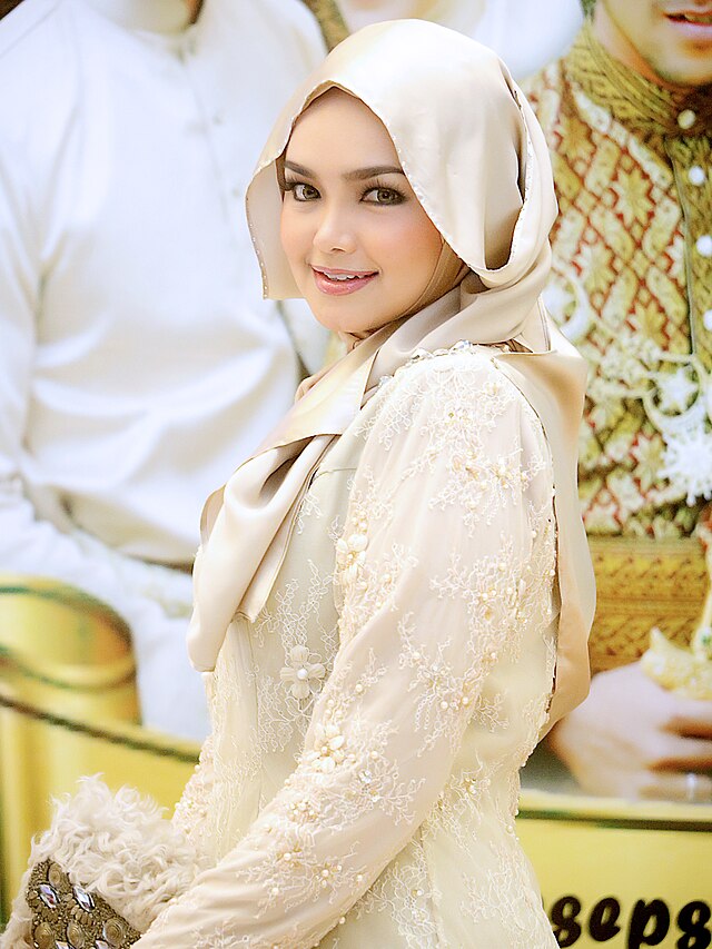 A woman in a cream colored hijab and outfit