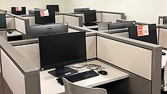 In this computer lab, every other workstation has been closed off to increase the distance between people working, and screens between workstations are also in place.