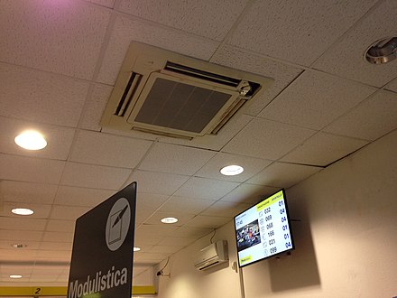 Ceiling mounted cassette AC and a wall-mounted AC in the background