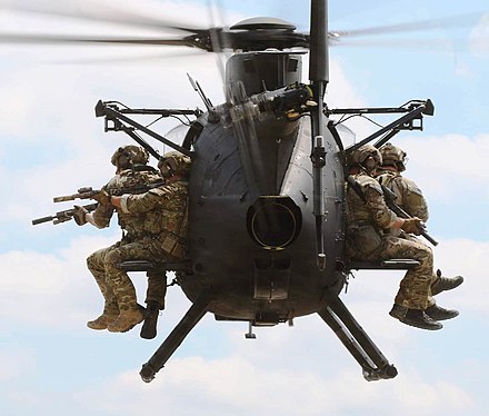 Troops seated on the outside of an MH-6M Little Bird