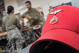U.S. Army's Parachute Rigger distinctive cover with Parachute Rigger Badge and rank insignia US Army Rigger red hat.jpg