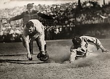 A baseball player slides into home base while an umpire calls safe.jpg