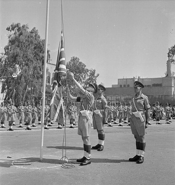 A sergeant of the Royal Military Police lowers the flag during the handover of Cairo Citadel to the Egyptians, 4 July 1946.