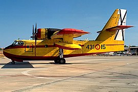 vue de profil d'un canadair jaune et rouge au sol.