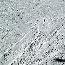 Tracks of carved turns in the snow, showing transition from one side of the ski to the other. Carving tracks snow.jpg