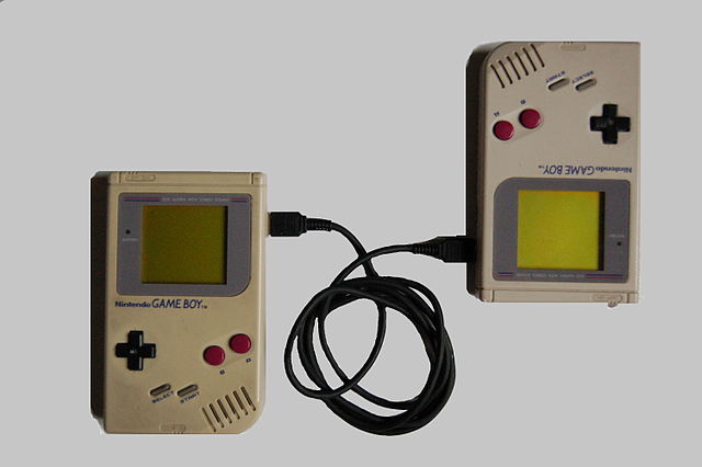 Two original Game Boys connected with a Game Link Cable
