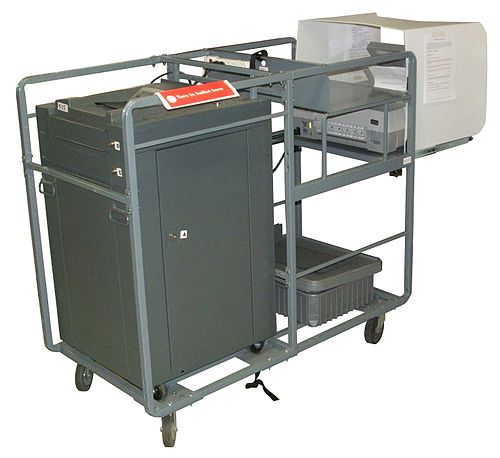 A cart holding an ES&S M100 ballot scanner and an AutoMARK assistive device, as used in Johnson County, Iowa, United States in 2010