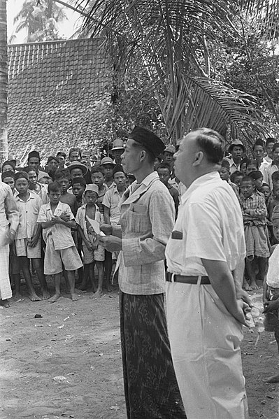 File:Een dorpshoofd (met peci) en een Indonesische man spreken een menigte toe, Bestanddeelnr 51-1-2.jpg