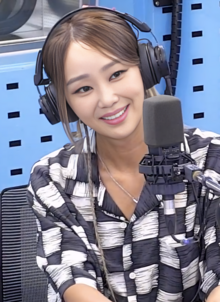 Hyolyn smiles while wearing headphones