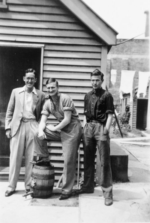 Left to right: Ian Milner, Denis Glover, and Robert William Lowry at the 'Dog-box', St Elmos flats, Christchurch. Taken by an unidentified photographe