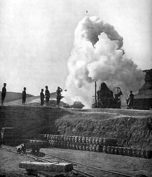 Japanese 11-inch howitzer firing; shell visible in flight