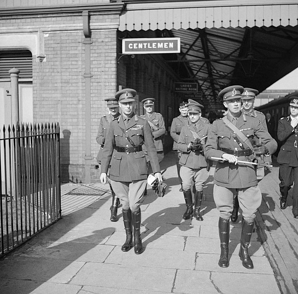 King George VI (left) with Major General John Grover (right) and several officers at a railway station at Gloucestershire, 1 April 1942.