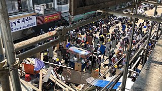 28. februar, demonstranter med skjolde bag barrikader i yangon.