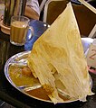 Image 58Roti tisu served as a savoury meal, pictured here with a glass of teh tarik. (from Malaysian cuisine)