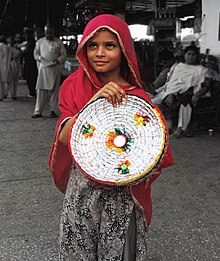 A young girl in a rural area of the Sindh province of Pakistan is selling these baskets her family has made for a living. Smile of Poverty.jpg