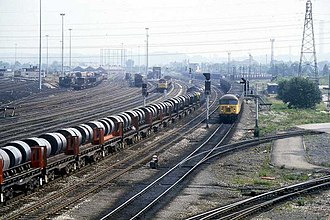 A classic mid-1980s shot of Toton, showing the Teesside Steelworks/Lackenby sidings - Corby Steelworks train on the up main line headed by a British Rail Class 37, whilst a British Rail Class 56 leaves the North Yard with coal empties on the second down goods line Toton Sidings - geograph.org.uk - 1624859.jpg