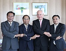 Vier Botschafter stehen bei der Verkündung des English Language Program for ASEAN Chairmanship vor der Kamera. Se halten sich über Kreuz an den Händen.