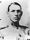 Hombre joven con el pelo corto peinado hacia abajo con un uniforme de la Marina de los EE. UU. De alrededor de 1915 con cuello muy alto.