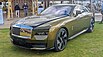 2023 Rolls Royce Spectre parked on a lawn at an auto show.