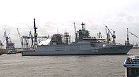 Die Frigatte wird vor dem Dock über das Achterschiff nach rechts gezogen. Im Dock ist das Heck der Nordrhein-Westfalen F223 zu erkennen