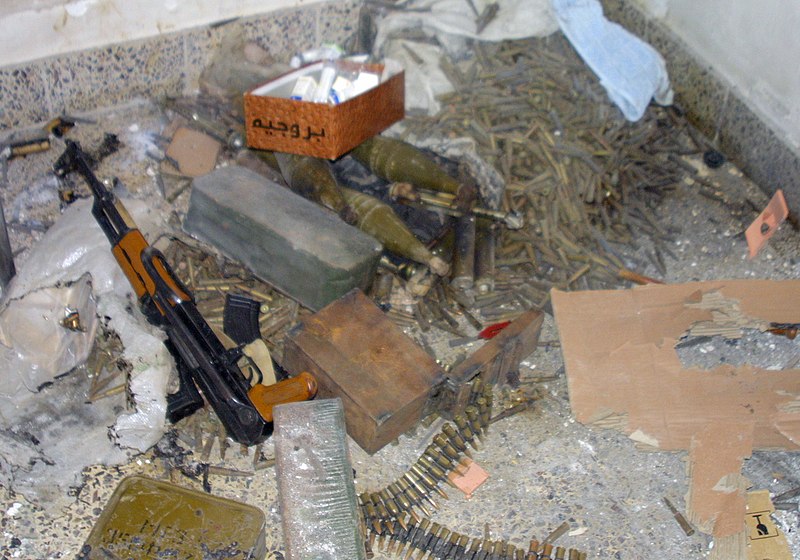 File:A large weapons cache including a 7.62mm AK-47 assault rifle, is found in the doorway of a house by US Marine Corps (USMC) Marine assigned to Bravo-Company, 1ST Battalion, 3rd Marin - DPLA - 15f50b5f3427d5a179a067337f62d481.jpeg