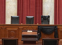 Courtroom with Ginsburg's seat draped in black, the day after her death Associate Justice Ruth Bader Ginsburg's chair and the bench in front of her seat at the Supreme Court draped in black.jpg