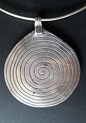 Silver pendant with spiral pattern of traditional Moroccan Berber jewellery, traditional side of a double-use piece Berber pendant with spiral pattern.jpg